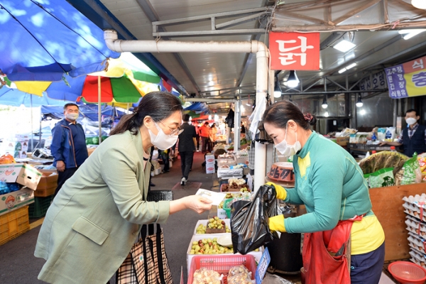 은수미 성남시장이 전통시장에서 지역상품권으로 물건값을 치르고 있다.