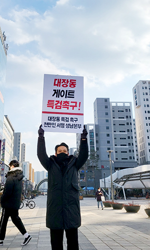 김현진 사무국장이 위례광장에서 대장동게이트의 특검을 촉구하는 일인시위를 하고 있다.